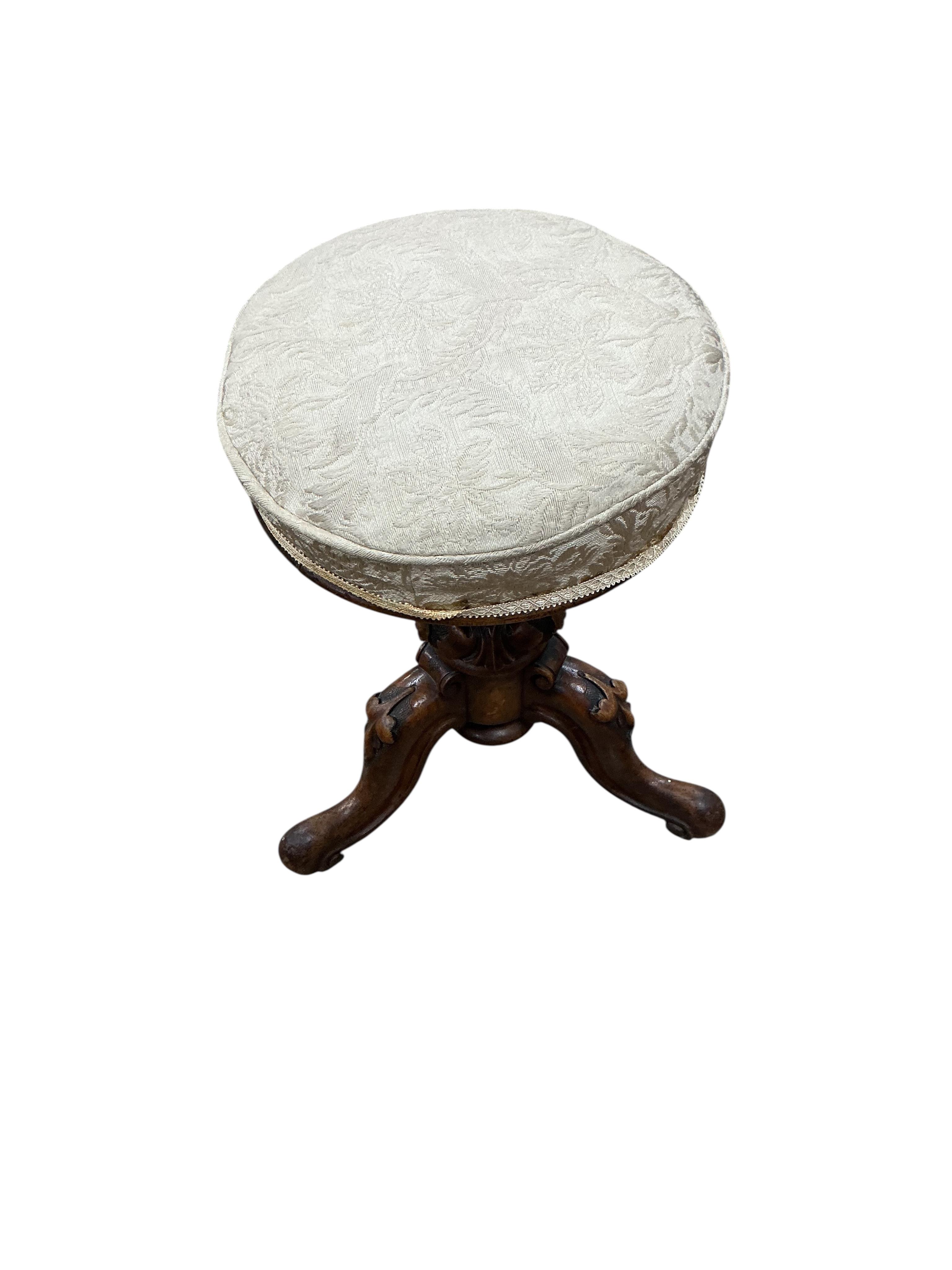 A Victorian walnut revolving piano stool